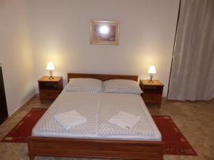 1 dormitorio con 1 cama grande y 2 mesitas de noche en Toscana Lakeside Apartments I - II Family friend, en Siófok