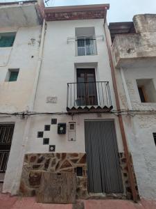 a white building with a window and a balcony at Casa rural El Mestre in Alcudia de Veo