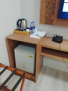 a desk with a computer under a table with a telephone at Coral Bay King Studio in Khor Fakkan