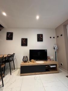 a living room with a television and a table at L'Escale in Sangatte