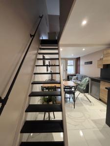 a staircase in a room with a table and a kitchen at L'Escale in Sangatte