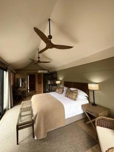 a bedroom with a bed and a ceiling fan at Mkhuze Trails Lodge in Hluhluwe