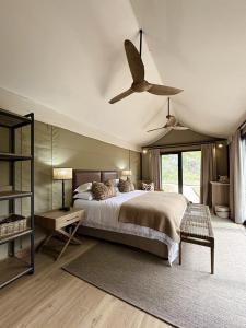 a bedroom with a bed and a ceiling fan at Mkhuze Trails Lodge in Hluhluwe +19 photos
