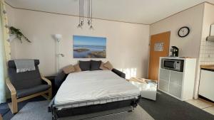 a bedroom with a bed and a chair in it at Ferienwohnung Auszeit Erika 1 in Burhave