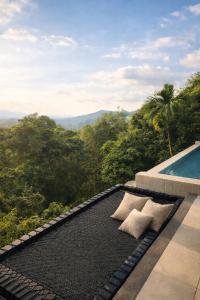 a black mat sitting next to a swimming pool at Exclusive Luxury 3-Bedroom Jungle Villa with Private Infinity Pool, Breathtaking Sea View & Peaceful Nature Escape in Mae Nam