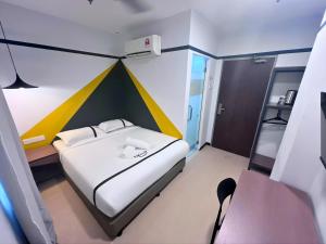 a small bedroom with a bed with a colorful wall at Smile Hotel Damansara Tropical in Petaling Jaya +24 photos