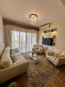 a living room with two couches and a television at Cozy crystal lounge in Sheikh Zayed