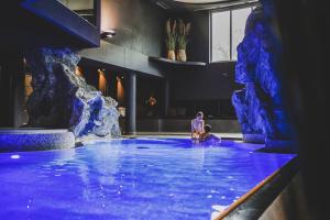 a water slide in a pool with two people in it at Hotel Ratschingserhof in Racines