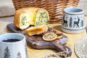 a slice of bread on a cutting board with a cup of coffee at Apartma pod macesnom in Jesenice