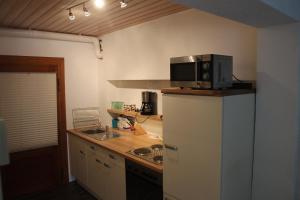 a kitchen with a microwave on top of a refrigerator at Ferienappartement Archimedes in Walkenried