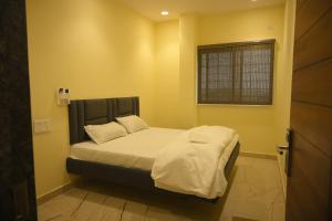 a bedroom with a bed with white sheets and a window at hotel NemiResidency in Jagdalpur