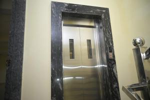 a mirror in a bathroom with a silver elevator at hotel NemiResidency in Jagdalpur