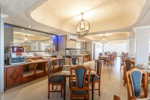 ein Esszimmer mit Tischen und Stühlen und eine Küche in der Unterkunft Gold Crest Hotel in Quatre Bornes