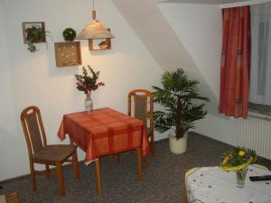 a dining room with a table and chairs and a plant at Gästehaus Nis Puk und Ferienwohnungen in Büsum