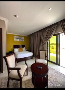 a bedroom with a bed and two chairs and a table at Voyager Inn-Hotel in Palatswe