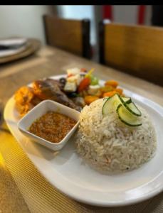 a plate of food with rice and a bowl of sauce at Voyager Inn-Hotel in Palatswe