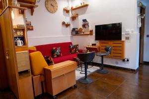a living room with a red couch and a chair at Alba Chiara in Acitrezza