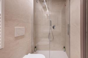 ein Badezimmer mit Dusche, Toilette und Waschbecken in der Unterkunft Aima Boutique Rooms in Costa Volpino