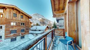 a balcony with a chair and a view of a mountain at Chalets LA MOURRA in Val-d'Isère