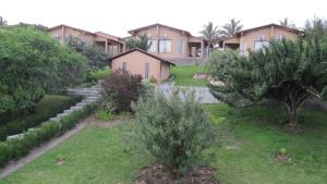 uma fila de casas com árvores num quintal em Massala Beach Resort, Lda em Vila Praia do Bilene