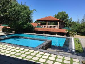 a swimming pool with a gazebo in the background at Massala Beach Resort, Lda in Vila Praia Do Bilene