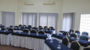 um quarto com mesas e cadeiras azuis e janelas em Massala Beach Resort, Lda em Vila Praia do Bilene