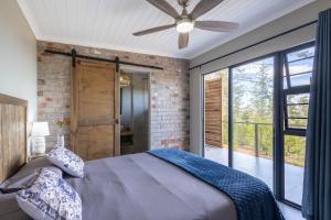 a bedroom with a bed and a ceiling fan at Myrtle Forest Retreat Cabin in Plettenberg Bay