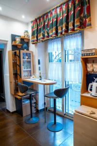a kitchen with a table and two stools in front of a window at Alba Chiara in Acitrezza