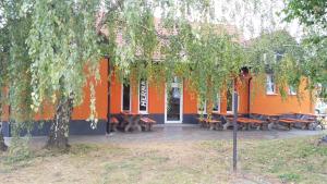 ein orangefarbenes Gebäude mit Picknicktischen davor in der Unterkunft Bed & Parking Eurobit in Hrušky