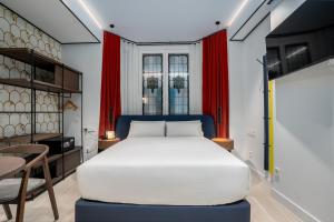 a bedroom with a large white bed and red curtains at Smartrental Collection Gran Vía Centric in Madrid