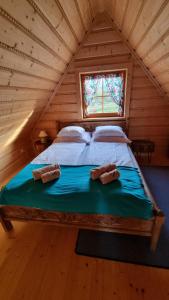 a large bed in a room with a window at Domki Szwajnosówka in Witów
