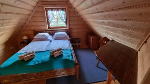 a bedroom with a bed in a log cabin at Domki Szwajnosówka in Witów +1 photo