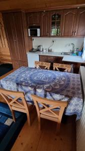 a kitchen with a table and some chairs and a table and a counter at Domki Szwajnosówka in Witów