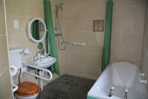 La salle de bains est pourvue de toilettes, d'un lavabo et d'une baignoire. dans l'établissement Glenboy Country Accommodation, à Oldcastle