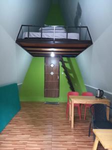 a room with a table and a bed on the ceiling at The Nest Park in Prigen