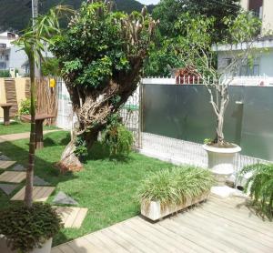 un jardín con valla, árboles y césped en Way Up Hostel, en Florianópolis