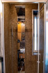 a glass shower in a bathroom with a mirror at Alba Chiara in Acitrezza +28 photos