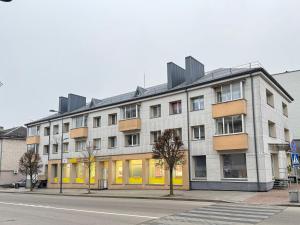 a large building on a city street with a street at Vytauto 12 - jaukūs apartamentai centre - Self Check-in in Marijampolė