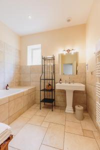 a bathroom with a tub and a sink and a bath tub at Château Bellevue-Domaines Loron in Villié-Morgon