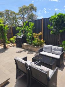 a patio with chairs and a couch and a table at Tiny House Experience in Sunset Strip