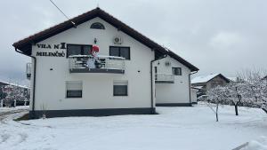 a dog on a balcony of a building in the snow at Milincic‘s 2 Zimmerwohnung in Banja Luka