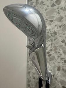 a chrome shower head on top of a sink at any one in Chitose