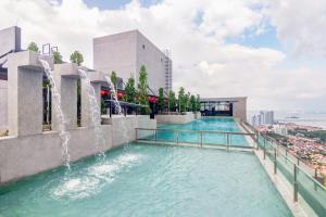a pool on the roof of a building with a fountain at Iconic Regency by Stellar ALV in Bayan Lepas
