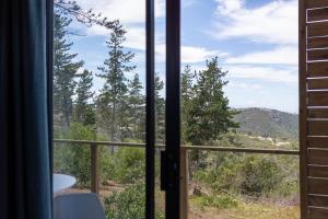 a window with a view of a mountain view at Pine Forest Retreat Cabin in Plettenberg Bay