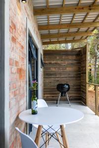 a white table and chairs on a patio at Pine Forest Retreat Cabin in Plettenberg Bay +9 photos