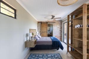 a bedroom with a bed and a brick wall at Pine Forest Retreat Cabin in Plettenberg Bay