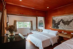 a bedroom with two beds and a large window at Issara Bar&House in Ko Larn