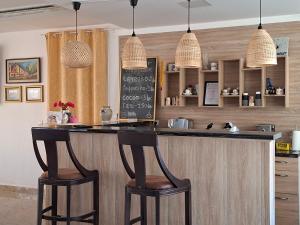 a kitchen with a counter with two stools at a bar at Hotel VIVA in Sofia