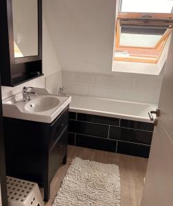 a bathroom with a sink and a bath tub at Maison moderne entre terre et mer in Coquelles +2 photos