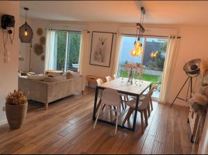 a living room with a table and a couch at Maison moderne entre terre et mer in Coquelles